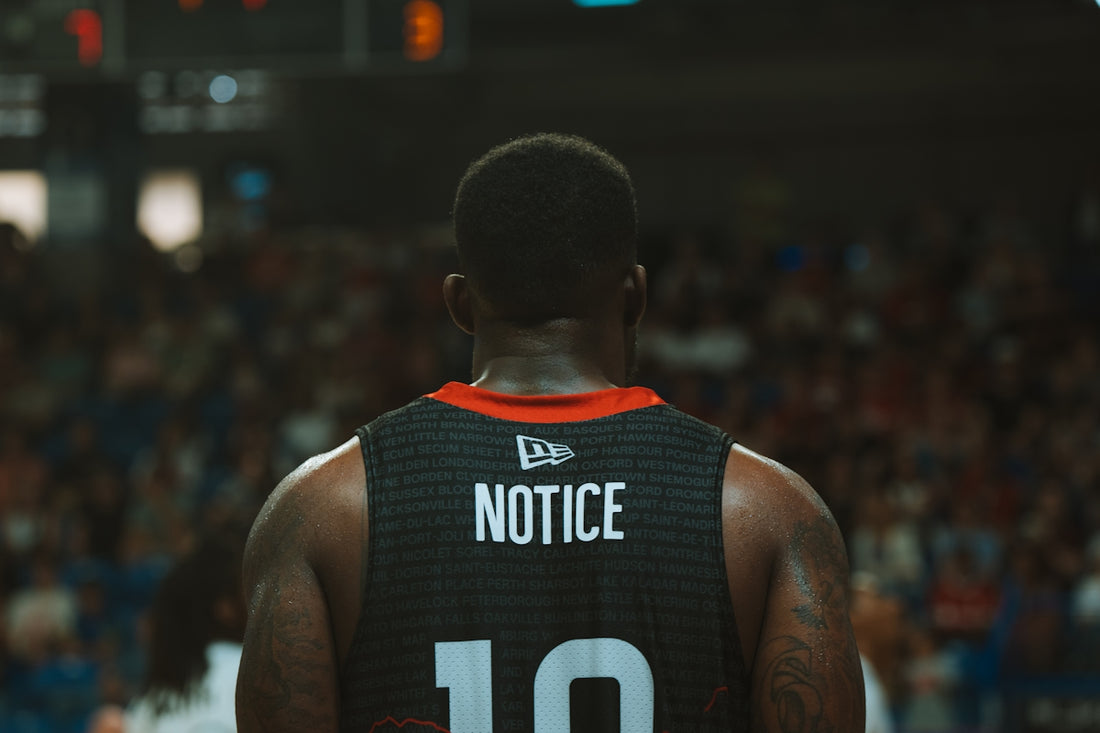 A basketball player stands ready in the stadium.